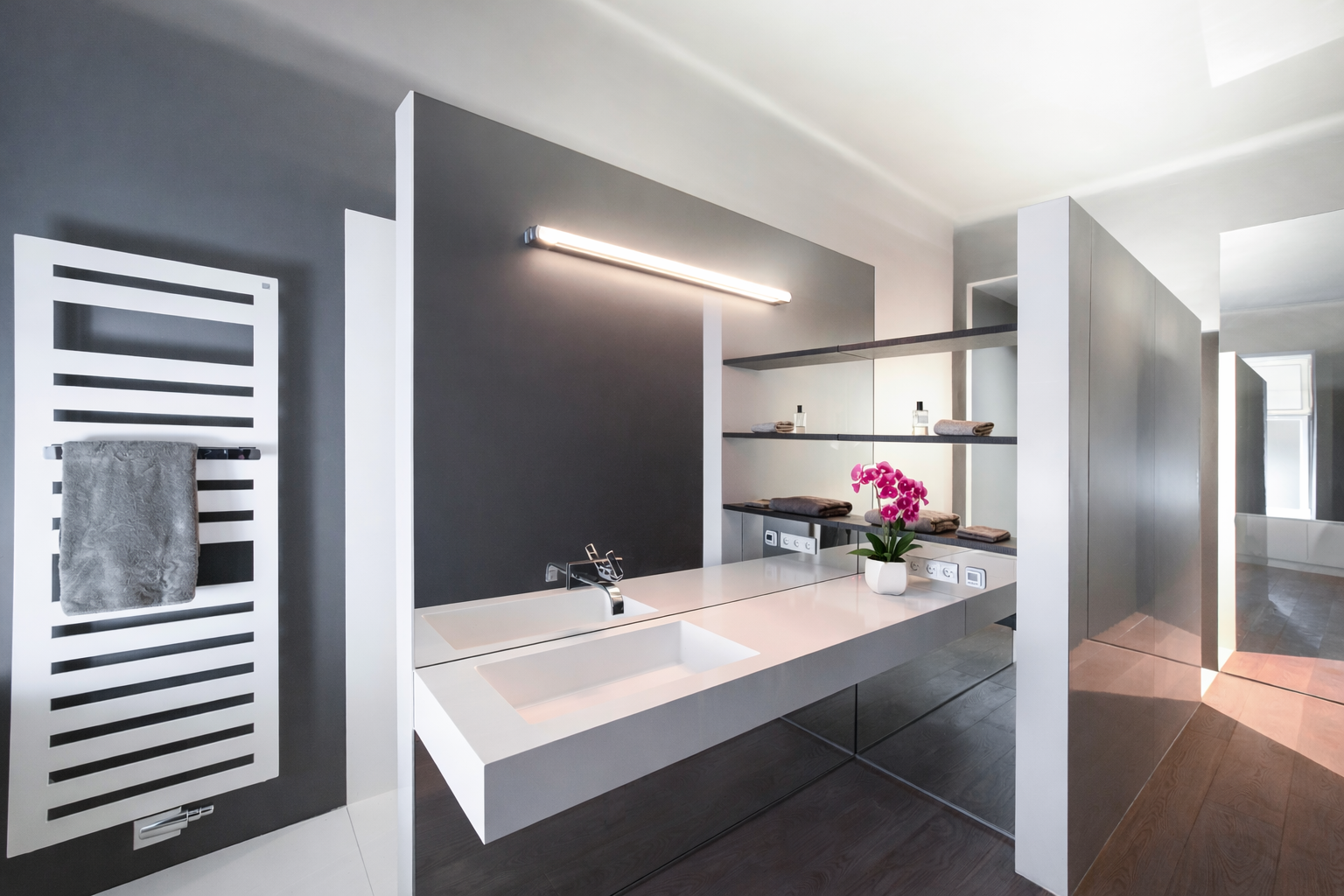 Grey bathroom with floating white double vanity and orchid