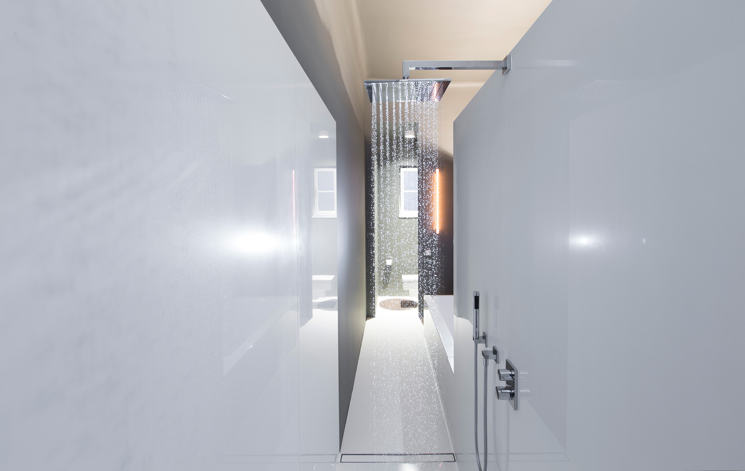 Walk-in rain shower with water falling between white panels