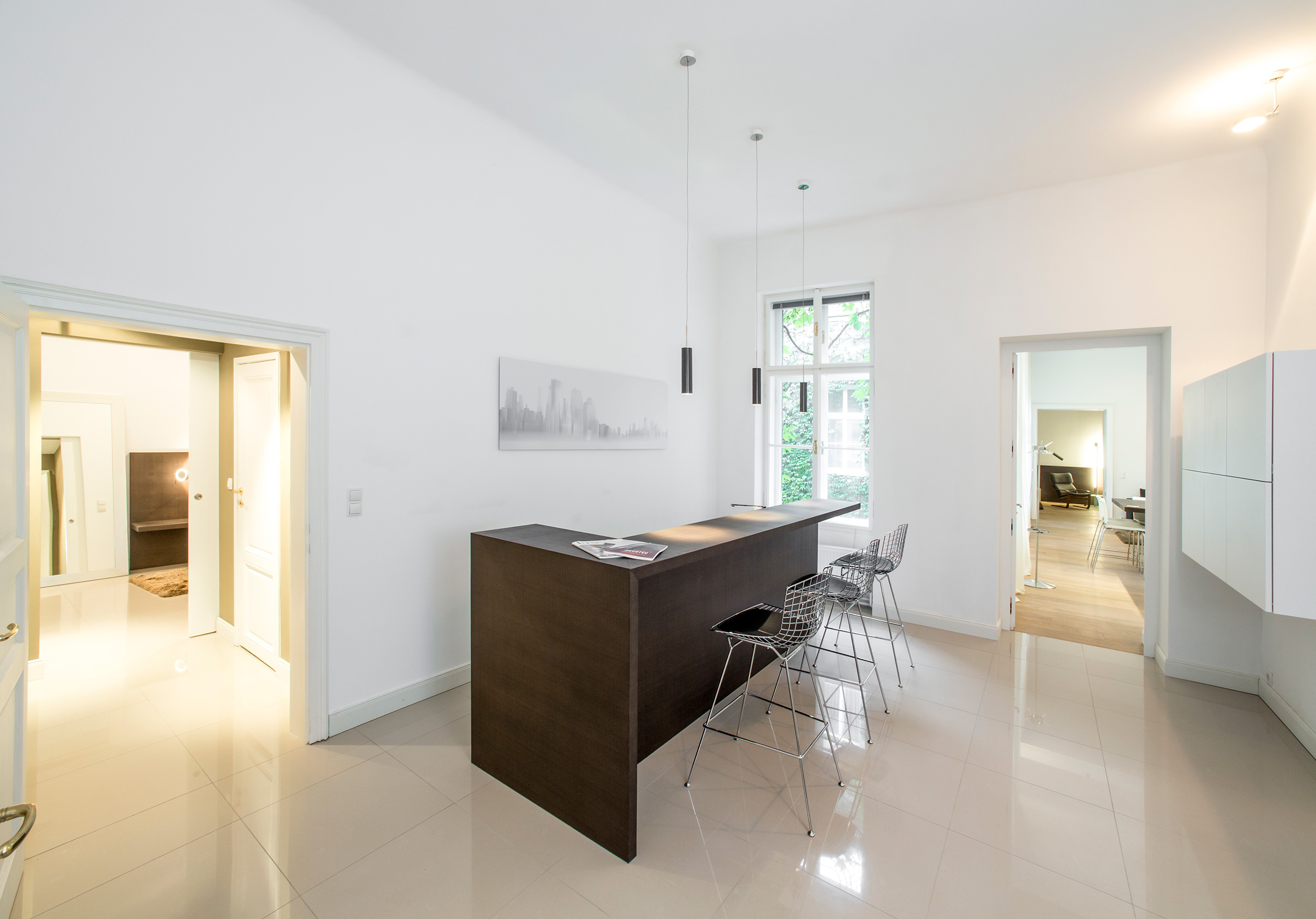 Bright breakfast bar with wire stools and tall windows onto greenery